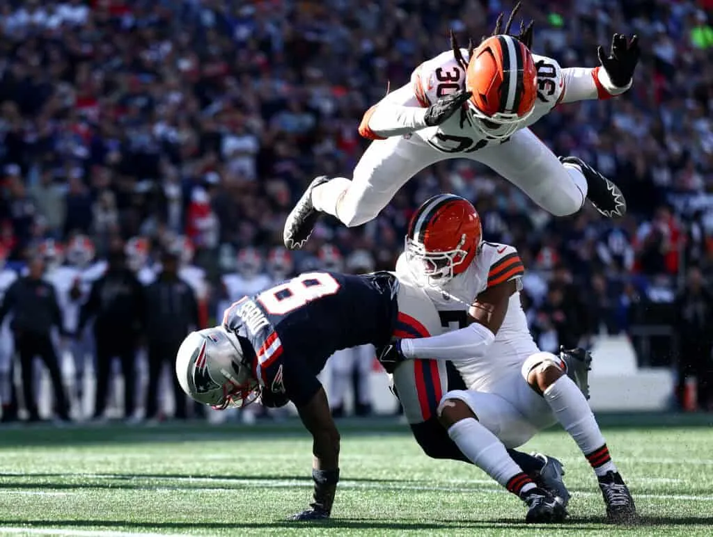 FOXBOROUGH, MASSACHUSETTS - OCTOBER 26: Stefon Diggs #8 of the New England Patriots scores a touchdown defended by Tyson Campbell #7 and Devin Bush #30 of the Cleveland Browns during the third quarter in the game at Gillette Stadium on October 26, 2025 in Foxborough, Massachusetts.