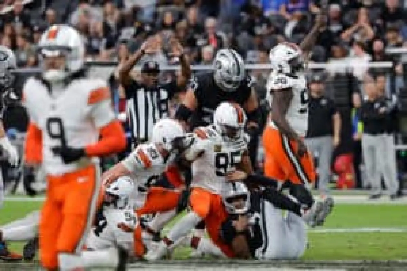 LAS VEGAS, NEVADA - NOVEMBER 23: Geno Smith #7 of the Las Vegas Raiders falls after being tackled by Cameron Thomas #99, Myles Garrett #95 and Maliek Collins #96 in the fourth quarter of a game at Allegiant Stadium on November 23, 2025 in Las Vegas, Nevada.