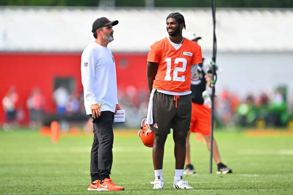 BEREA, OHIO - JULY 26: Head coach Kevin Stefanski talks to quarterback Shedeur Sanders #12 of the Cleveland Browns during training camp at CrossCountry Mortgage Campus on July 26, 2025 in Berea, Ohio.