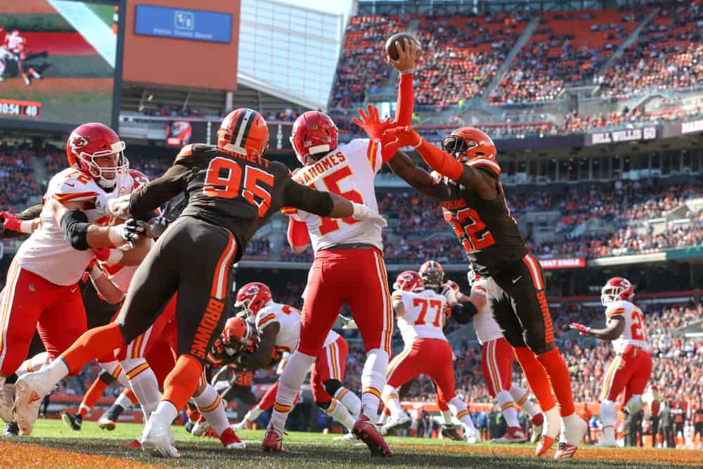 Kansas City Chiefs quarterback Patrick Mahomes (15) throws a pass out of his own end zone as Cleveland Browns defensive end Myles Garrett (95) and Cleveland Browns safety Jabrill Peppers (22) apply pressure during the first quarter of the National Football League game between the Kansas City Chiefs and Cleveland Browns on November 4, 2018, at FirstEnergy Stadium in Cleveland, OH.