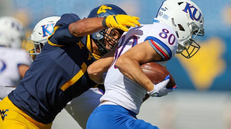 West Virginia Mountaineers linebacker Tony Fields II (1) makes a tackle on Kansas Jayhawks wide receiver Luke Grimm (80) during the first quarter of the college football game between the Kansas Jayhawks and the West Virginia Mountaineers on October 17, 2020, at Mountaineer Field at Milan Puskar Stadium in Morgantown, WV. Fields II was called for a horse collar tackle on the play.