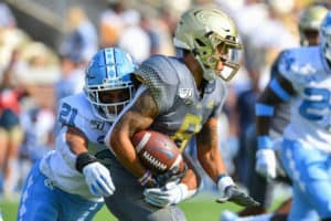 Georgia Tech Yellow Jackets quarterback Tobias Oliver (8) runs the ball and is tackled by North Carolina Tar Heels linebacker Chazz Surratt (21) during the NCAA football game between the North Carolina Tar Heels and the Georgia Tech Yellow Jackets on October 5th, 2019 at Bobby Dodd Stadium in Atlanta, GA.