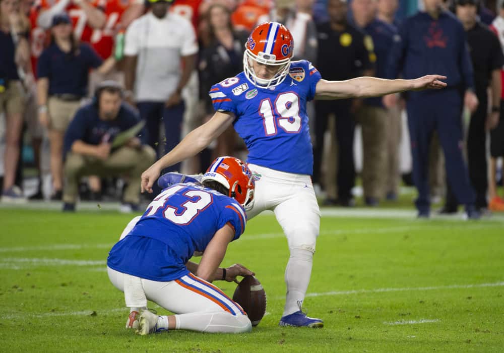 Florida Gators punter Tommy Townsend (43) holds the ball as Florida Gators kicker Evan McPherson (19) kicks for an extra point during the College Football game between the Florida Gators and the Virginia Cavaliers at the Capital One Orange Bowl on December 30, 2019 at the Hard Rock Stadium in Miami Gardens, FL.