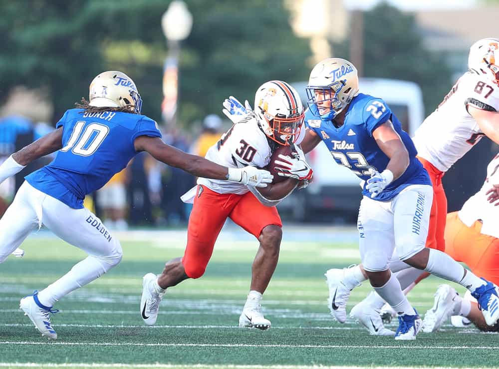 Oklahoma State Cowboys RB Chuba Hubbard (30) runs through the tackle attempt by Tulsa Golden Hurricane S Manny Bunch (10) and Tulsa Golden Hurricane LB Zaven Collins (23) during a college football game between the Tulsa Golden Hurricane and the Oklahoma State Cowboys on September 14, 2019, at H.A. Chapman Stadium in Tulsa, OK.