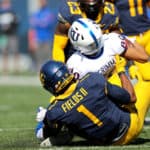 West Virginia Mountaineers linebacker Tony Fields II (1) makes a tackle on Kansas Jayhawks wide receiver Luke Grimm (80) during the first quarter of the college football game between the Kansas Jayhawks and the West Virginia Mountaineers on October 17, 2020, at Mountaineer Field at Milan Puskar Stadium in Morgantown, WV. Fields II was called for a horse collar tackle on the play.