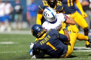 West Virginia Mountaineers linebacker Tony Fields II (1) makes a tackle on Kansas Jayhawks wide receiver Luke Grimm (80) during the first quarter of the college football game between the Kansas Jayhawks and the West Virginia Mountaineers on October 17, 2020, at Mountaineer Field at Milan Puskar Stadium in Morgantown, WV. Fields II was called for a horse collar tackle on the play.