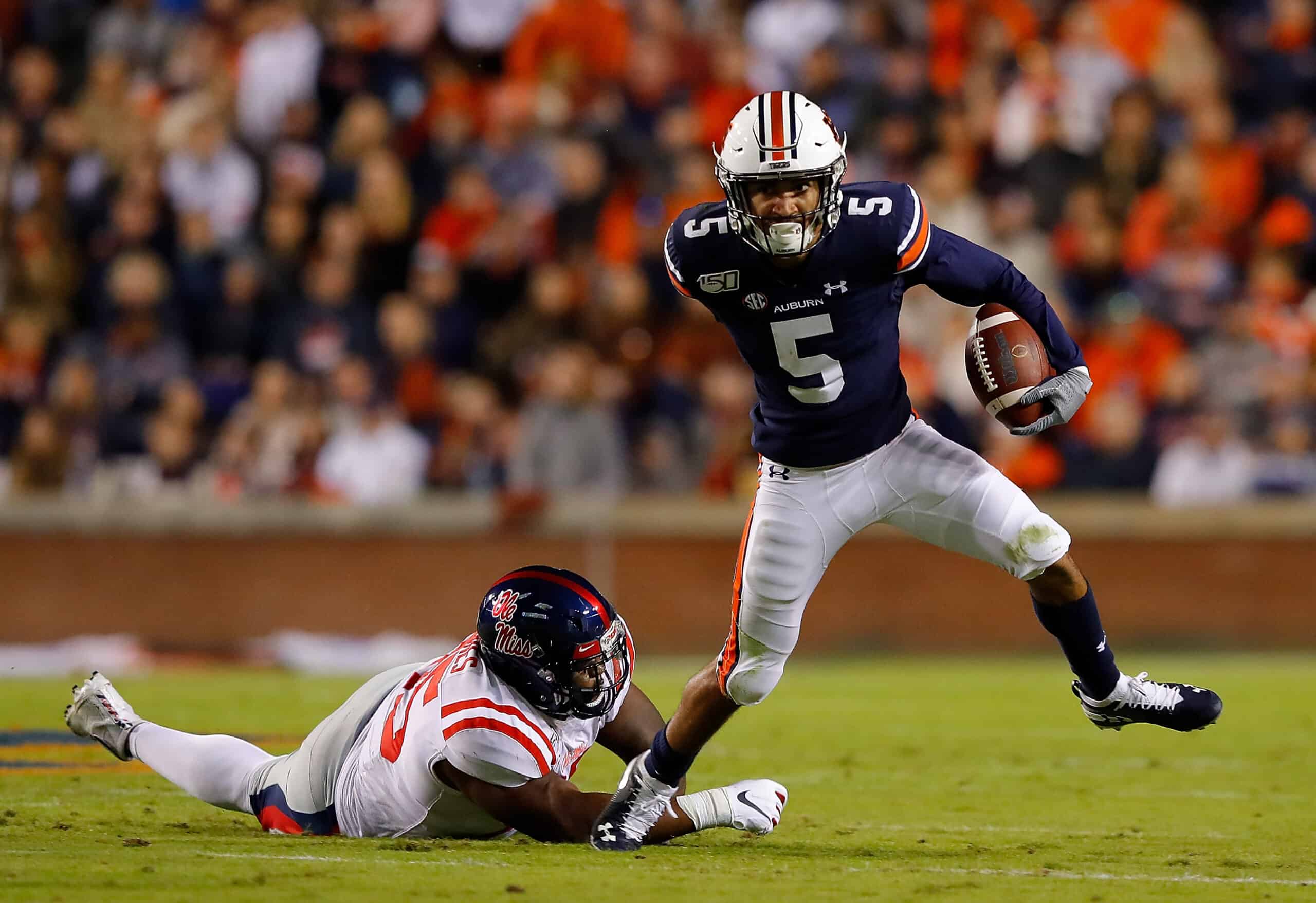 Anthony Schwartz #5 of the Auburn Tigers breaks a tackle by Benito Jones #95 of the Mississippi Rebels in the first half at Jordan-Hare Stadium on November 02, 2019 in Auburn, Alabama.