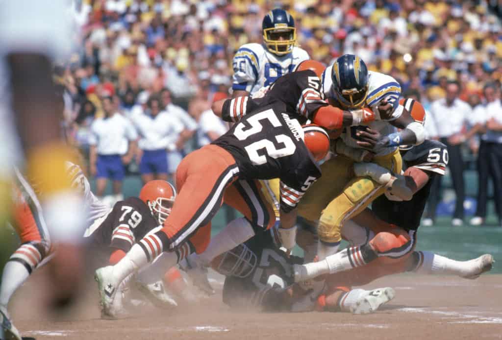 Linebackers Dick Ambrose #52 and Tom Cousineau #50, Chip Banks #54 of the Cleveland Browns tackle running back Chuck Muncie #46 of the San Diego Chargers during a game at Jack Murphy Stadium on September 25, 1983 in San Diego, California. The Browns won 30-24 in overtime.