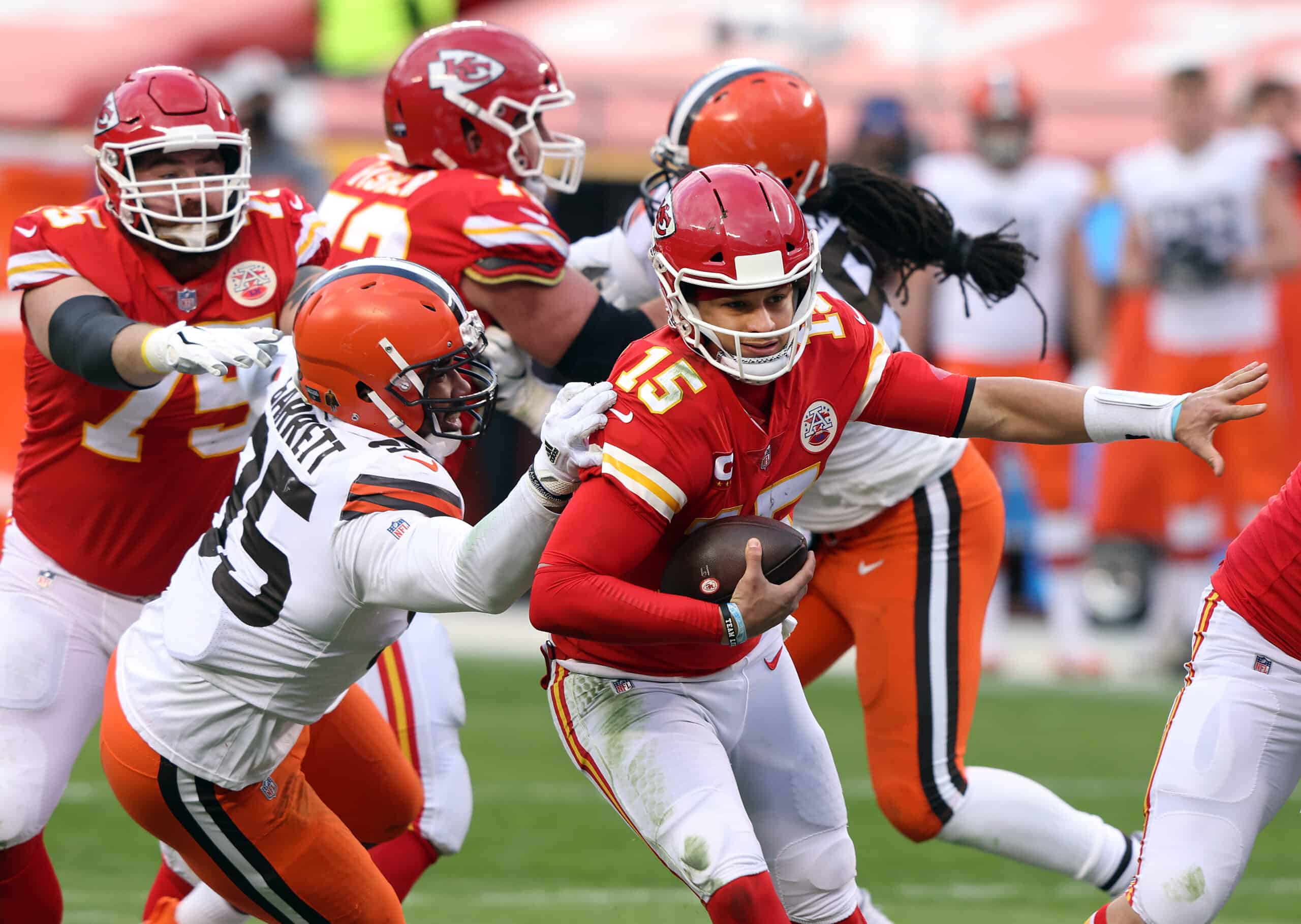 Quarterback Patrick Mahomes #15 of the Kansas City Chiefs scrambles as defensive end Myles Garrett #95 of the Cleveland Browns chases during the AFC Divisional Playoff game at Arrowhead Stadium on January 17, 2021 in Kansas City, Missouri.