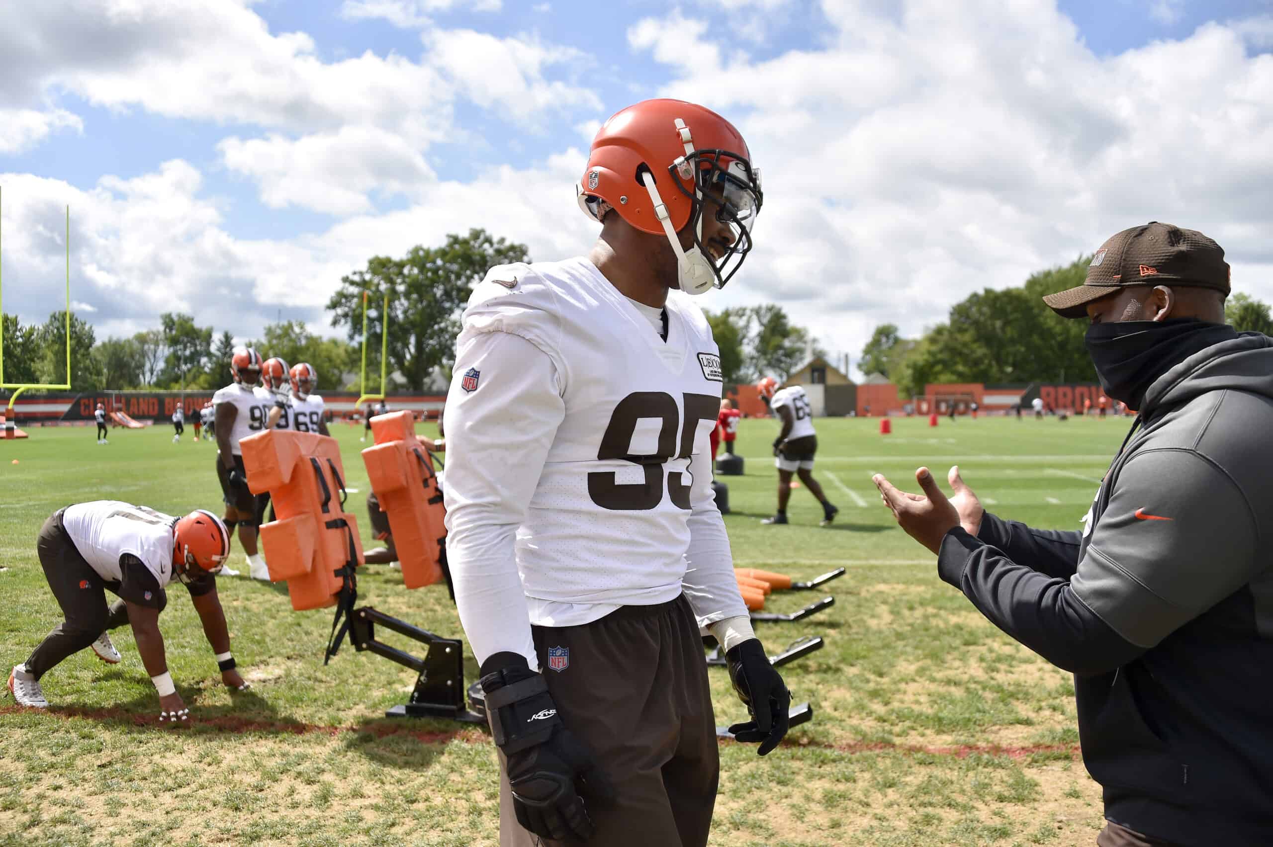 Defensive end Myles Garrett #95 of the Cleveland Browns talks with a member of the coaching staff during training camp at the Browns training facility on August 29, 2020 in Berea, Ohio.