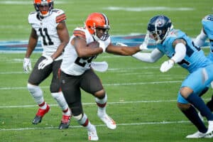 Nick Chubb #24 of the Cleveland Browns carries the ball against Kenny Vaccaro #24 of the Tennessee Titans in the first quarter at Nissan Stadium on December 06, 2020 in Nashville, Tennessee.