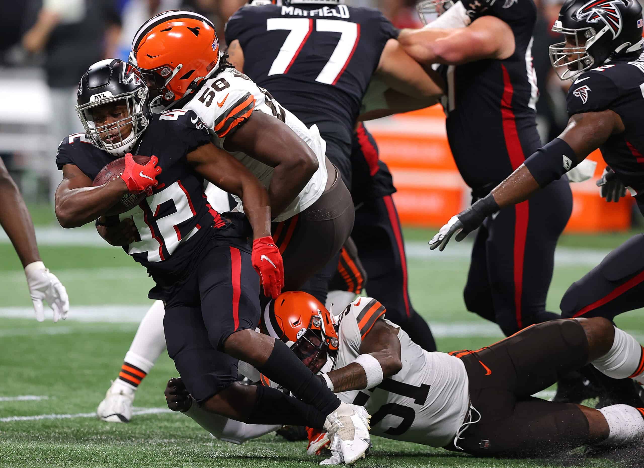 Caleb Huntley #42 of the Atlanta Falcons is tackled by Malik McDowell #58 and Mack Wilson #51 of the Cleveland Browns during the first half at Mercedes-Benz Stadium on August 29, 2021 in Atlanta, Georgia.