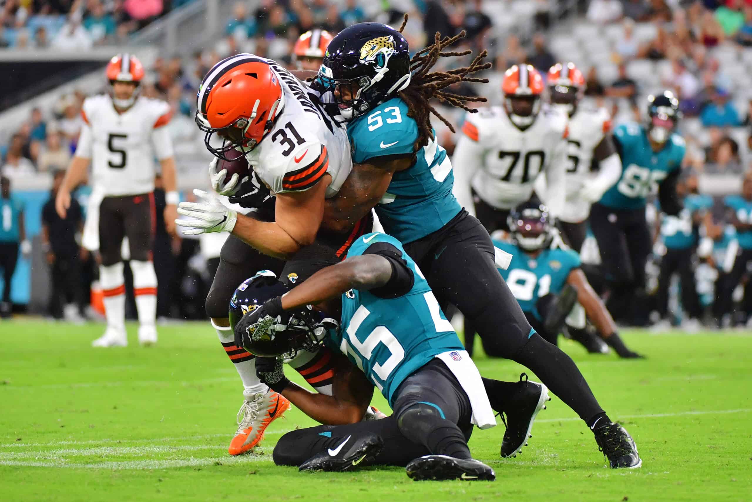 Andy Janovich #31 of the Cleveland Browns is brought down by Dakota Allen #53 and Jarrod Wilson #25 of the Jacksonville Jaguars in the first half during a preseason game at TIAA Bank Field on August 14, 2021 in Jacksonville, Florida. 