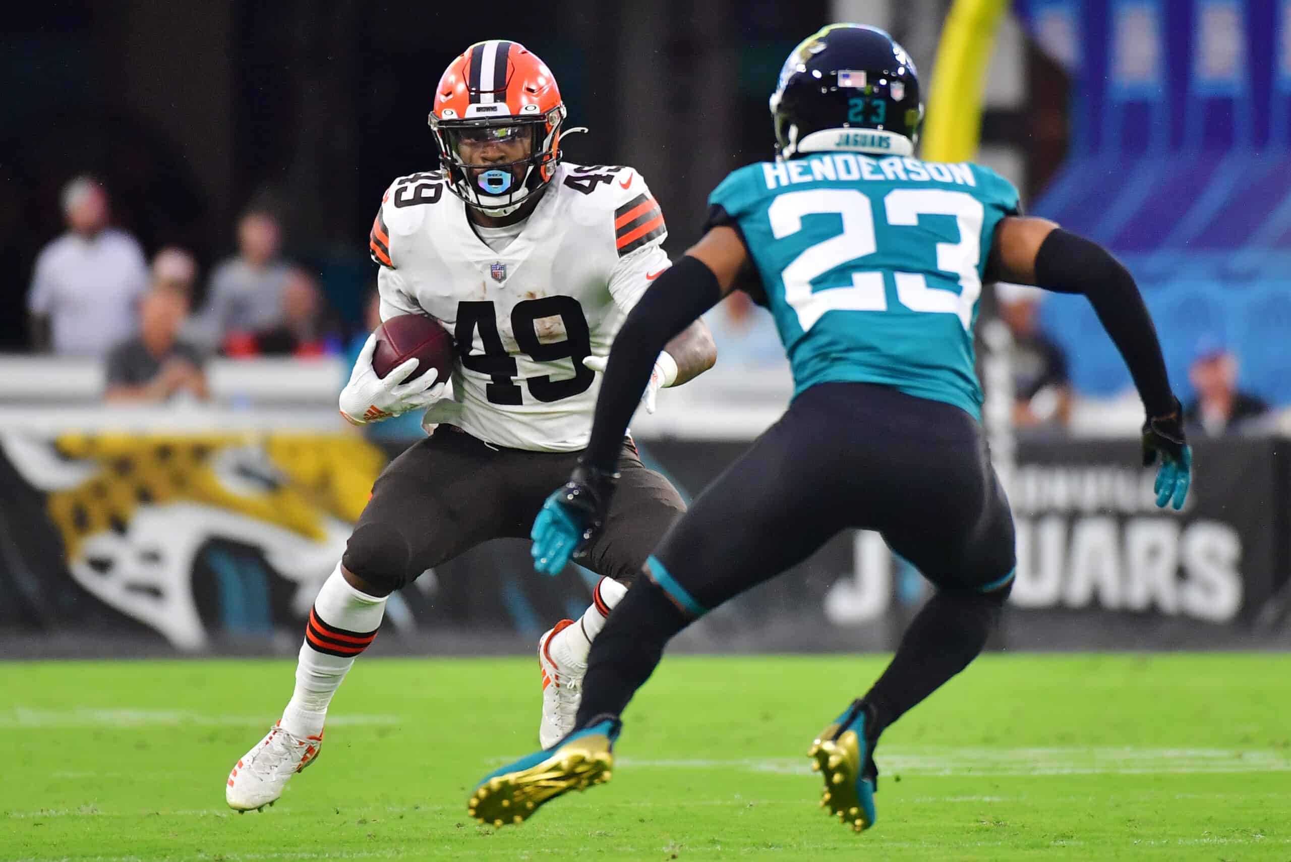 C.J. Henderson #23 of the Jacksonville Jaguars looks to tackle John Kelly #49 of the Cleveland Browns in the second quarter during a preseason game at TIAA Bank Field on August 14, 2021 in Jacksonville, Florida.