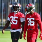 Jamel Dean #35 and Herb Miller #36 of the Tampa Bay Buccaneers converse during the Buccaneers Mini-Camp at AdventHealth Training Center on June 08, 2021 in Tampa, Florida.
