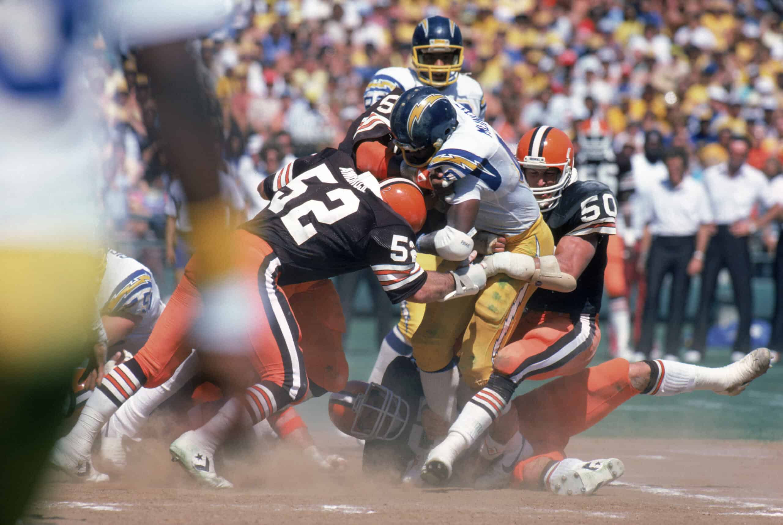 Linebackers Dick Ambrose #52 and Tom Cousineau #50 of the Cleveland Browns tackle running back Chuck Muncie #46 of the San Diego Chargers during a game at Jack Murphy Stadium on September 25, 1983 in San Diego, California. The Browns won 30-24 in overtime.