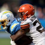 Mike Williams #81 of the Los Angeles Chargers is wrapped up by Greedy Williams #26 of the Cleveland Browns during a 47-42 win over the Cleveland Browns at SoFi Stadium on October 10, 2021 in Inglewood, California.