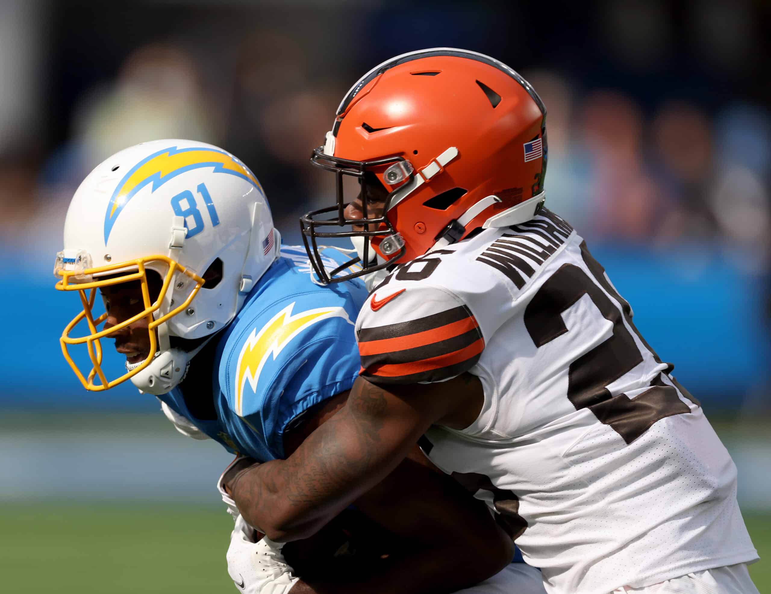 Mike Williams #81 of the Los Angeles Chargers is wrapped up by Greedy Williams #26 of the Cleveland Browns during a 47-42 win over the Cleveland Browns at SoFi Stadium on October 10, 2021 in Inglewood, California.