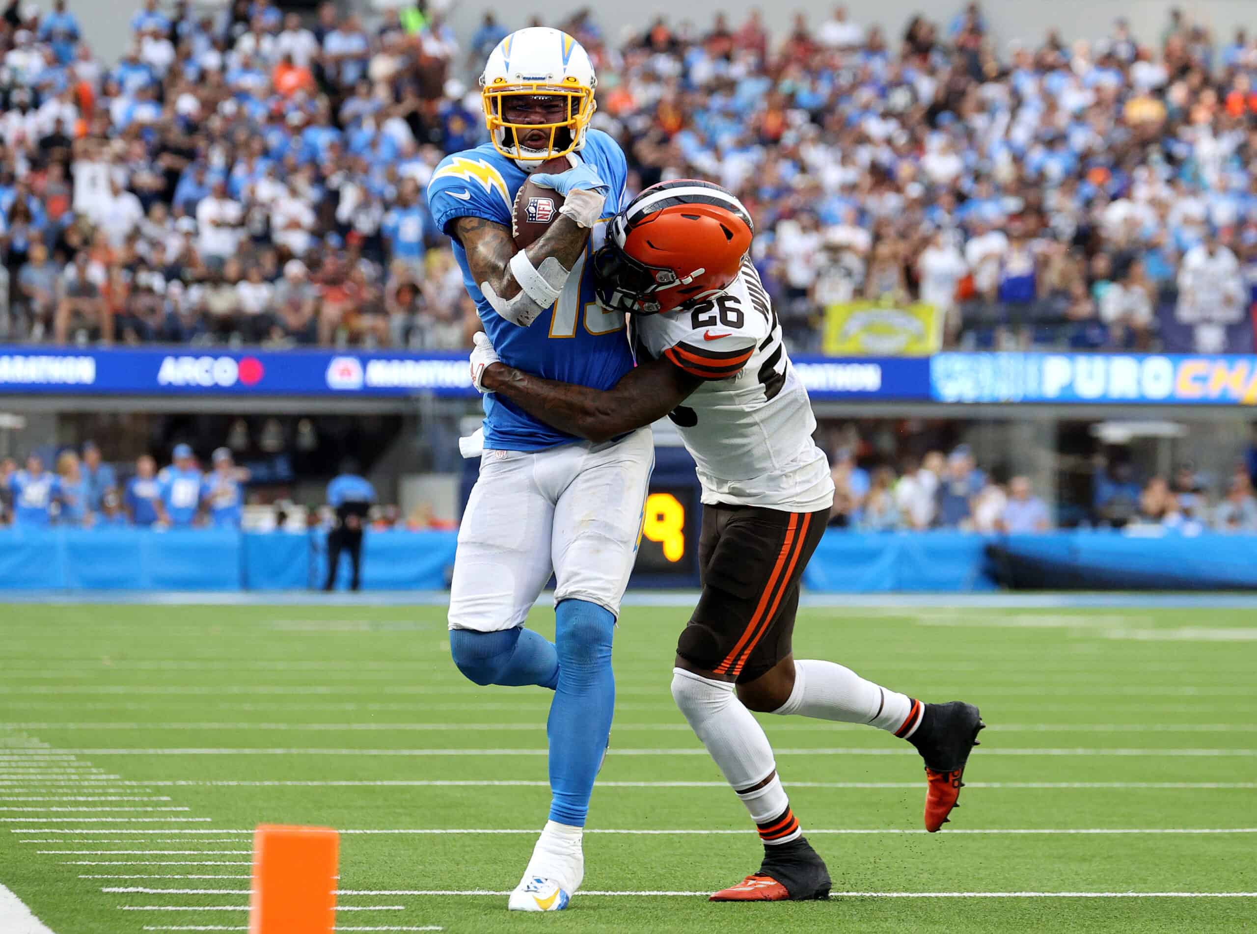 Keenan Allen #13 of the Los Angeles Chargers is tackled by Greedy Williams #26 of the Cleveland Browns after his catch during a 47-42 win over the Cleveland Browns at SoFi Stadium on October 10, 2021 in Inglewood, California.