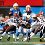 Austin Ekeler #30 of the Los Angeles Chargers runs the ball and is hit by Jeremiah Owusu-Koramoah #28, Sione Takitaki #44, and Ronnie Harrison #33 of the Cleveland Browns during the fourth quarter at SoFi Stadium on October 10, 2021 in Inglewood, California.