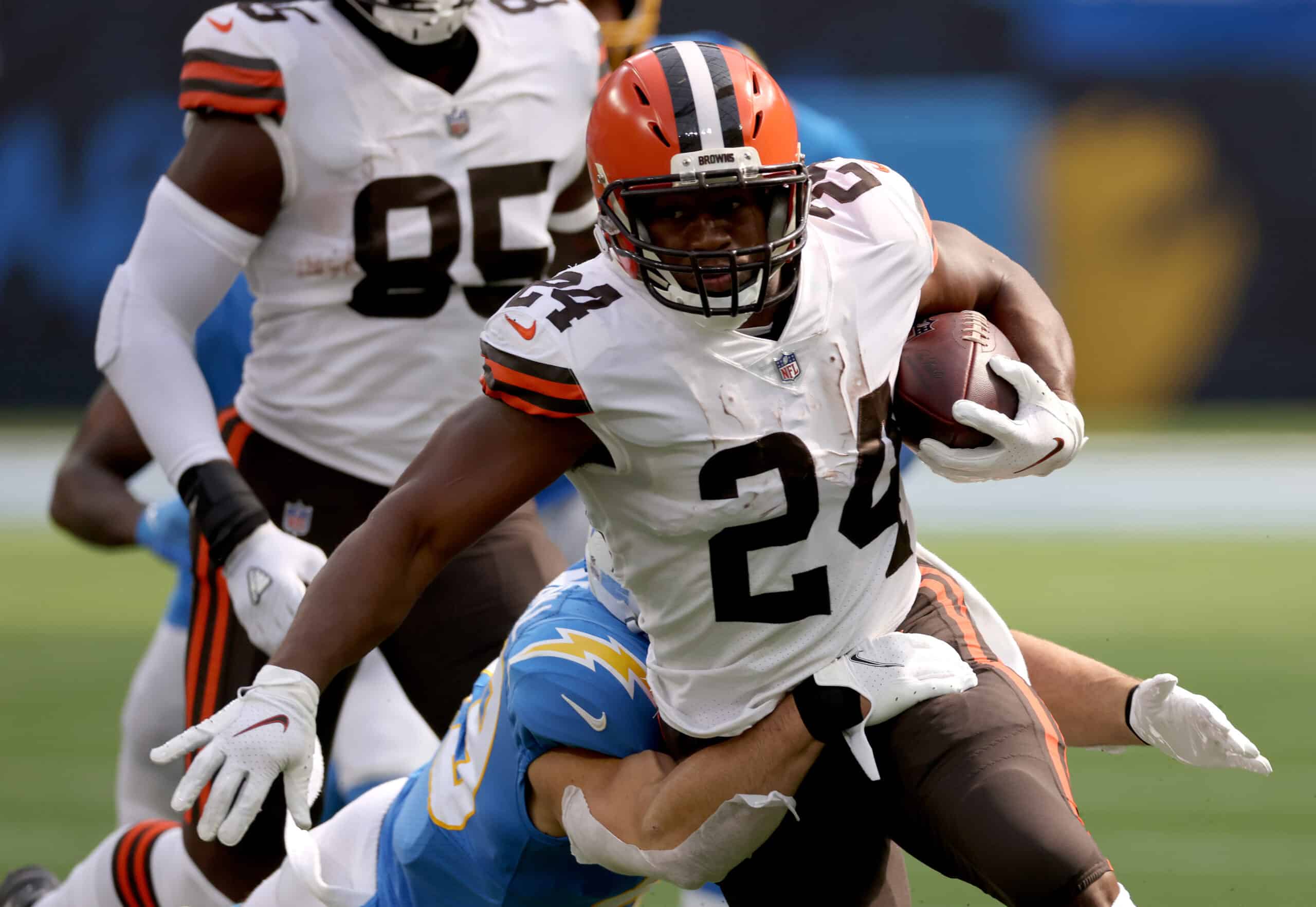 Nick Chubb #24 of the Cleveland Browns runs as he is tackled by Drue Tranquill #49 of the Los Angeles Chargers during a 49-42 loss to the Los Angeles Chargers at SoFi Stadium on October 10, 2021 in Inglewood, California.