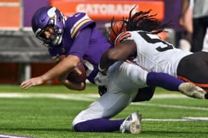 Kirk Cousins #8 of the Minnesota Vikings is tackled by Takkarist McKinley #55 of the Cleveland Browns at U.S. Bank Stadium on October 03, 2021 in Minneapolis, Minnesota.