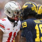 Jaxon Smith-Njigba #11 of the Ohio State Buckeyes and Rod Moore #19 of the Michigan Wolverines talk during the first quarter at Michigan Stadium on November 27, 2021 in Ann Arbor, Michigan.
