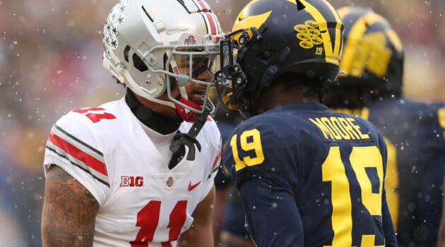 Jaxon Smith-Njigba #11 of the Ohio State Buckeyes and Rod Moore #19 of the Michigan Wolverines talk during the first quarter at Michigan Stadium on November 27, 2021 in Ann Arbor, Michigan.