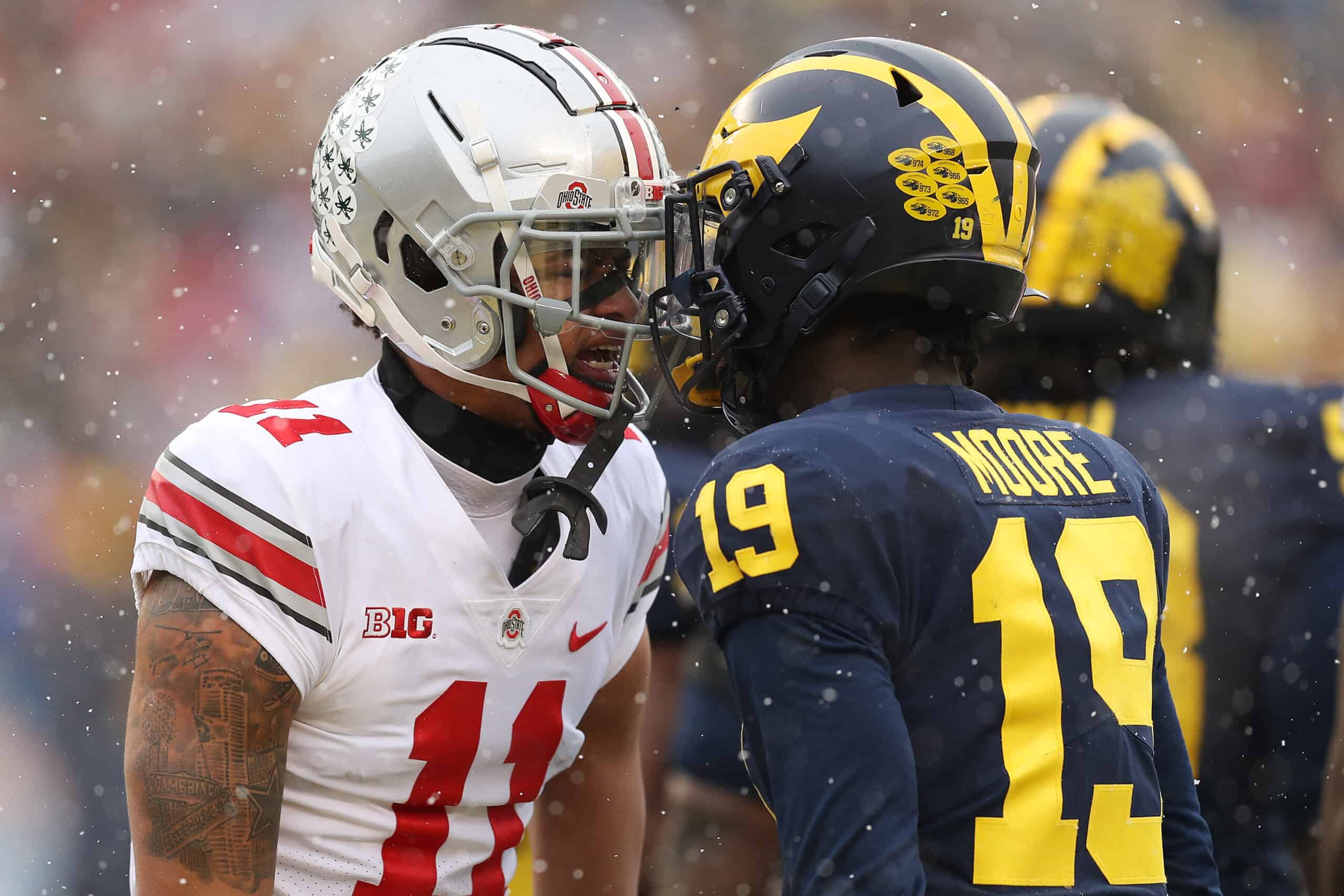 Jaxon Smith-Njigba #11 of the Ohio State Buckeyes and Rod Moore #19 of the Michigan Wolverines talk during the first quarter at Michigan Stadium on November 27, 2021 in Ann Arbor, Michigan.