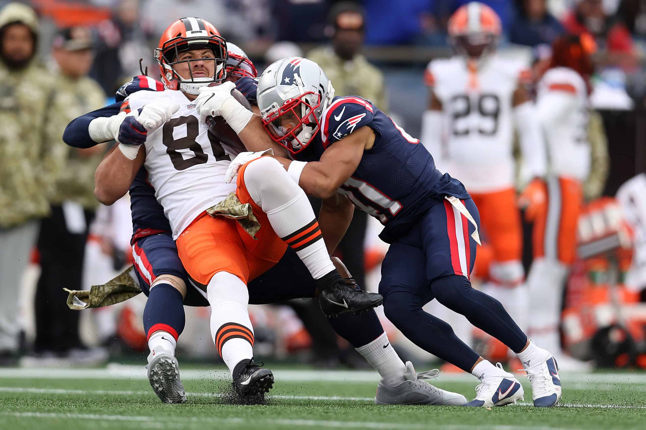 Austin Hooper #81 of the Cleveland Browns is tackled by Dont'a Hightower #54 and Myles Bryant #41 of the New England Patriots during the third quarter at Gillette Stadium on November 14, 2021 in Foxborough, Massachusetts. 