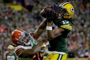 Davante Adams #17 of the Green Bay Packers makes a catch for a touchdown while being guarded by M.J. Stewart Jr. #36 of the Cleveland Browns in the second quarter at Lambeau Field on December 25, 2021 in Green Bay, Wisconsin.