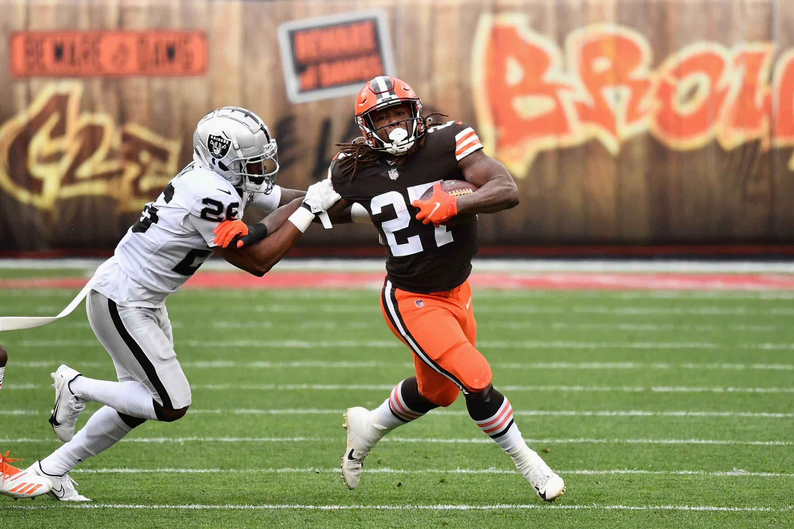 Running back Kareem Hunt #27 of the Cleveland Browns rushes the football past cornerback Nevin Lawson #26 of the Las Vegas Raiders during the first half of the NFL game at FirstEnergy Stadium on November 01, 2020 in Cleveland, Ohio.