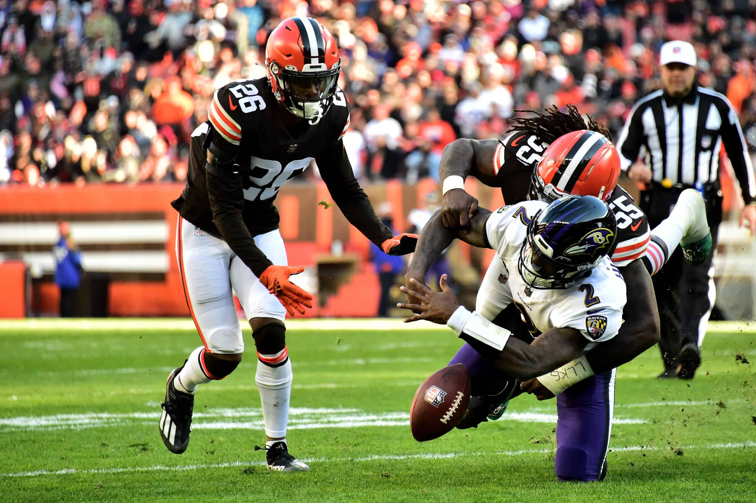 Takkarist McKinley #55 of the Cleveland Browns strips the ball loose from Tyler Huntley #2 of the Baltimore Ravens for a fumble during the third quarter at FirstEnergy Stadium on December 12, 2021 in Cleveland, Ohio. 