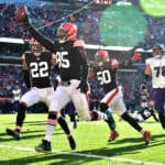 Myles Garrett #95 of the Cleveland Browns runs the ball into the end zone for a touchdown after a fumble recovery in the second quarter against the Baltimore Ravens at FirstEnergy Stadium on December 12, 2021 in Cleveland, Ohio.