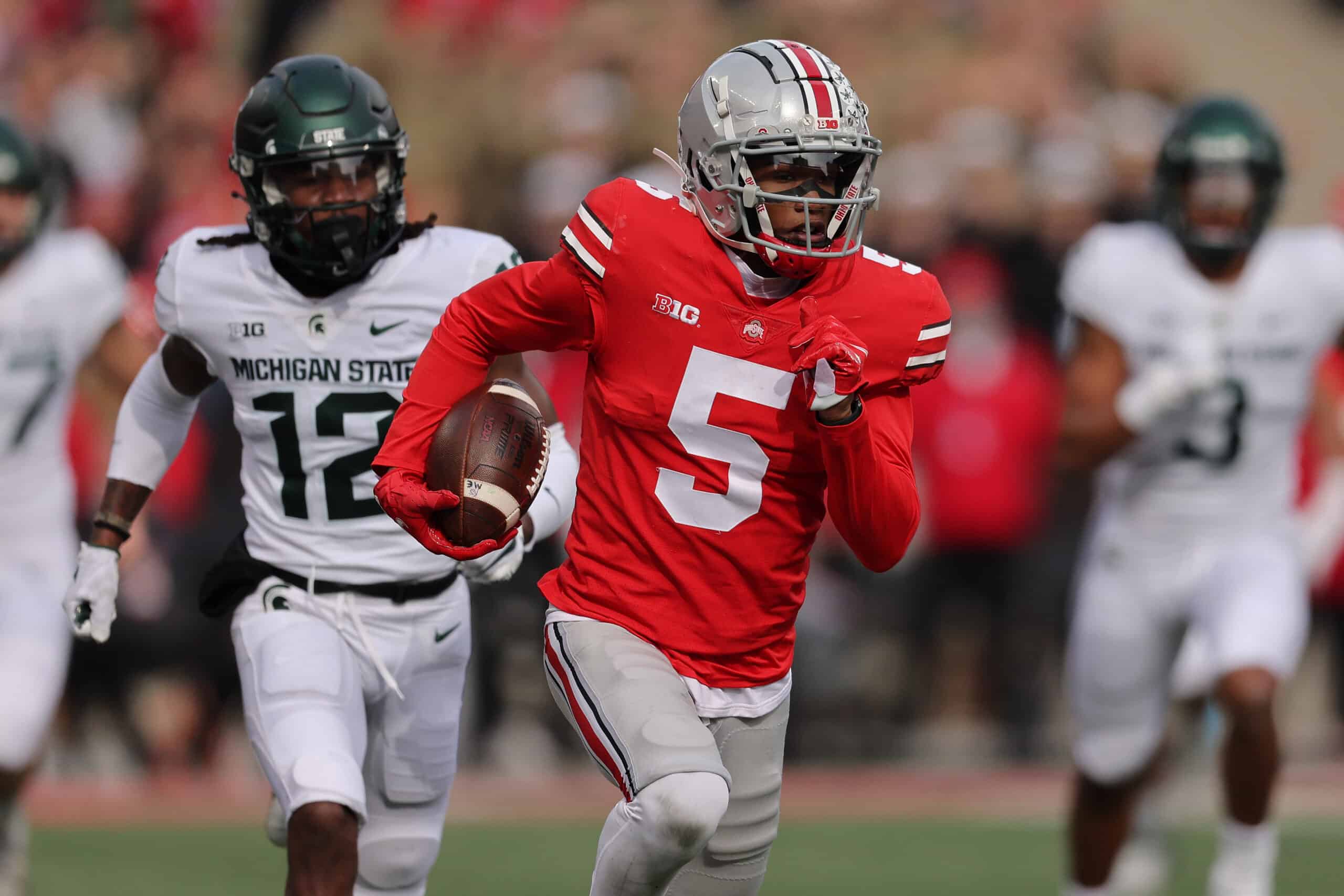 Garrett Wilson #5 of the Ohio State Buckeyes catches a first quarter touchdown pass in front of Chester Kimbrough #12 of the Michigan State Spartans at Ohio Stadium on November 20, 2021 in Columbus, Ohio. 