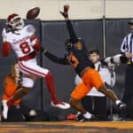 Wide receiver Michael Woods II #8 of the Oklahoma Sooners tries to catch a pass in the end zone but instead picks up a pass interference penalty against safety Thomas Harper #13 of the Oklahoma State Cowboys in the first quarter at Boone Pickens Stadium on November 27, 2021 in Stillwater, Oklahoma.