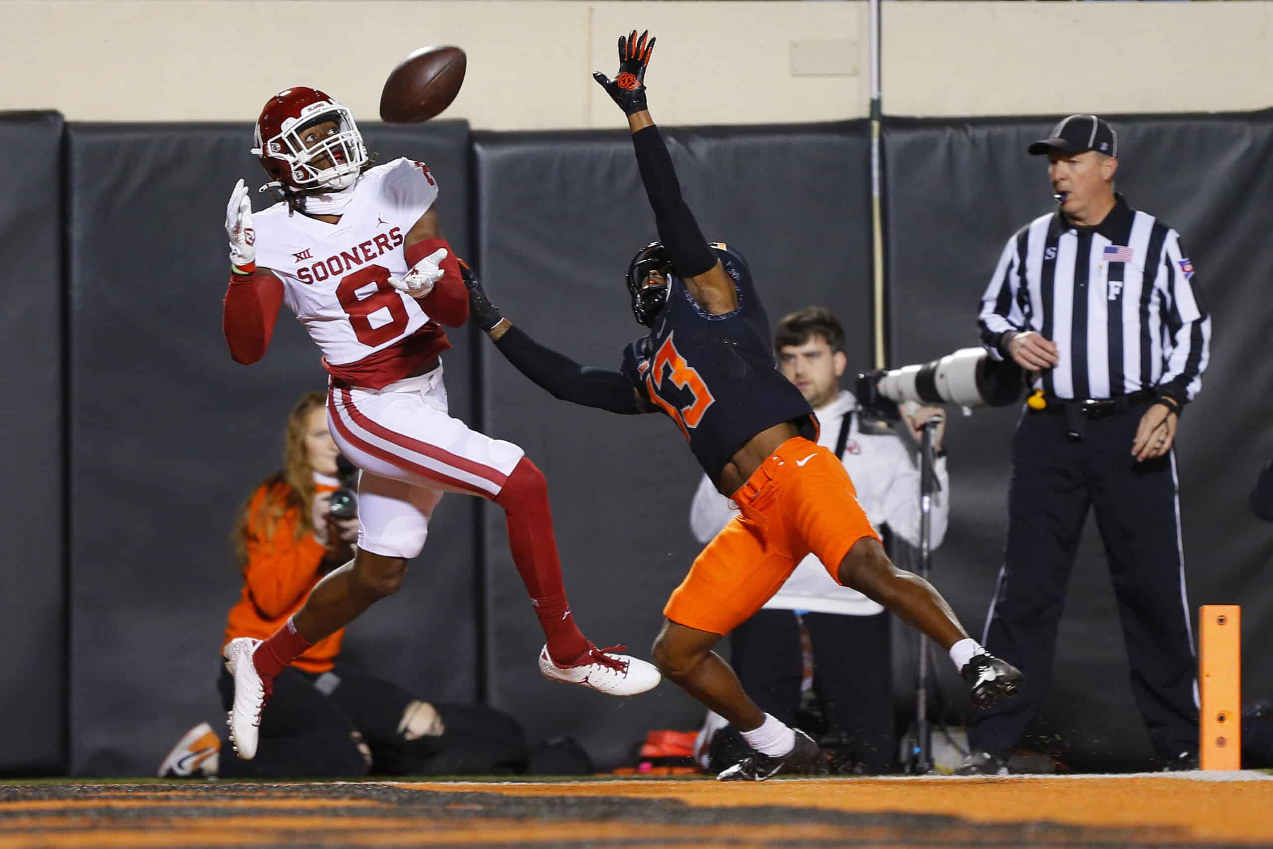 Wide receiver Michael Woods II #8 of the Oklahoma Sooners tries to catch a pass in the end zone but instead picks up a pass interference penalty against safety Thomas Harper #13 of the Oklahoma State Cowboys in the first quarter at Boone Pickens Stadium on November 27, 2021 in Stillwater, Oklahoma.