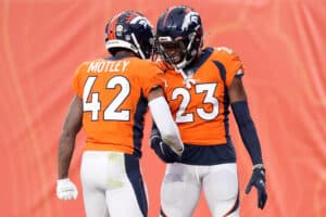 Michael Ojemudia #23 of the Denver Broncos celebrates with Parnell Motley #42 after recovering a fumble against the Las Vegas Raiders in the second quarter at Empower Field At Mile High on January 03, 2021 in Denver, Colorado.