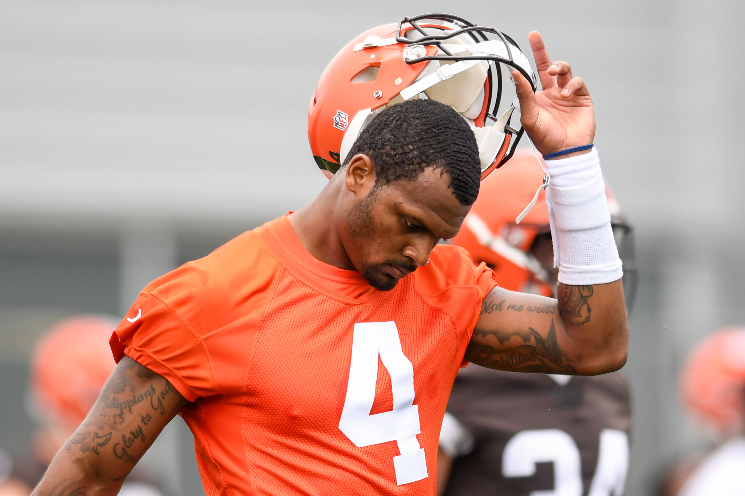 Deshaun Watson #4 of the Cleveland Browns takes off his helmet as he warms up during the Cleveland Browns mandatory minicamp at CrossCountry Mortgage Campus on June 14, 2022 in Berea, Ohio.