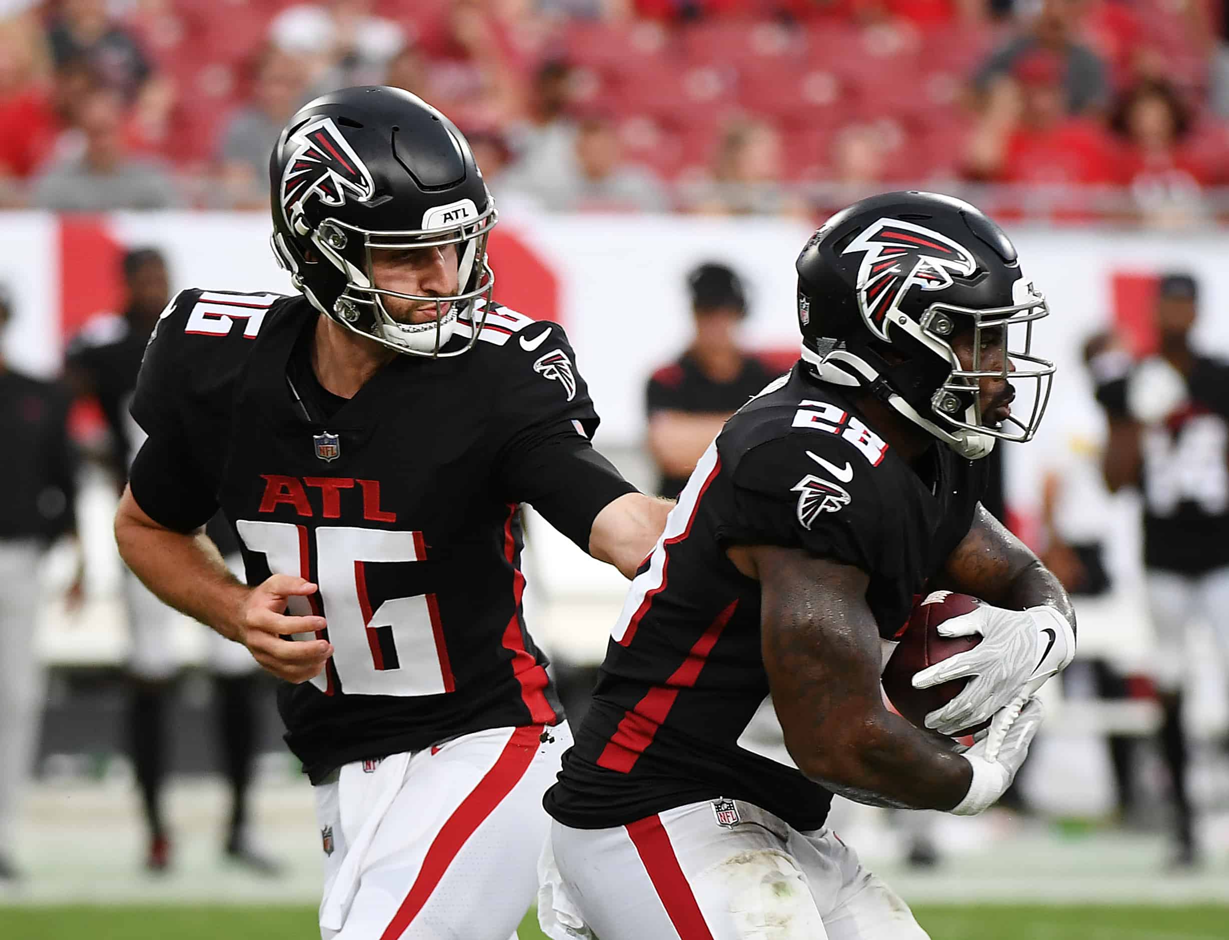 Quarterback Josh Rosen #16 of the Atlanta Falcons hands off the ball to Mike Davis #28 in the fourth quarter of the game against the Tampa Bay Buccaneers at Raymond James Stadium on September 19, 2021 in Tampa, Florida. 