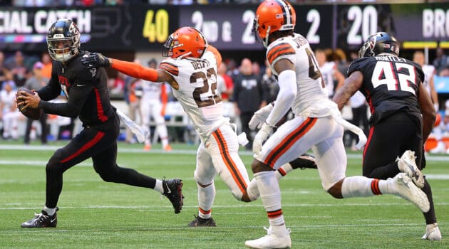 Marcus Mariota #1 of the Atlanta Falcons runs with the ball against Grant Delpit #22 of the Cleveland Browns after a bobble snap during the fourth quarter at Mercedes-Benz Stadium on October 02, 2022 in Atlanta, Georgia.