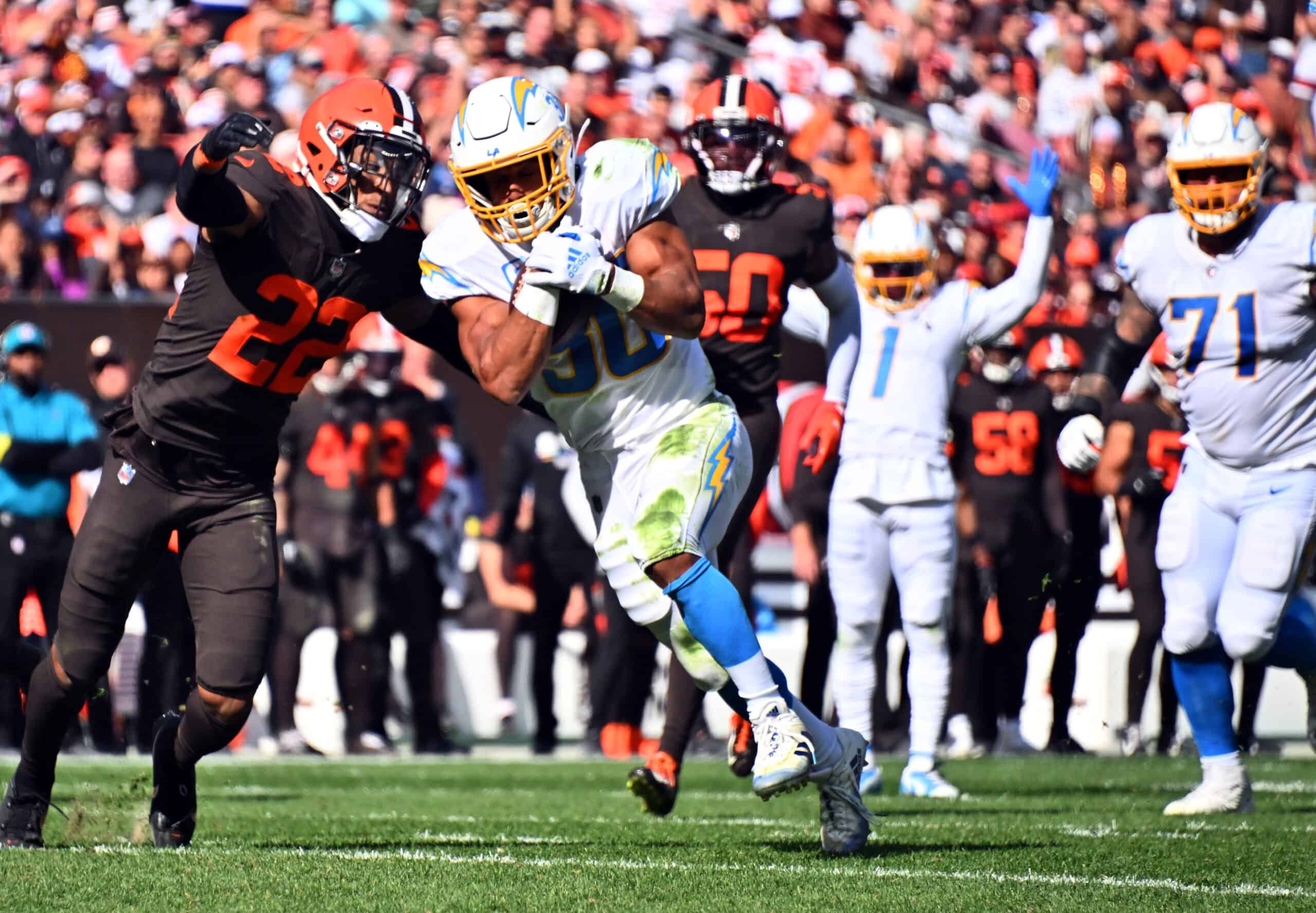 Grant Delpit #22 of the Cleveland Browns tackles Austin Ekeler #30 of the Los Angeles Chargers while scoring a touchdown during the third quarter at FirstEnergy Stadium on October 09, 2022 in Cleveland, Ohio.