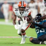 Jerome Ford #34 of the Cleveland Browns looks to break the tackle of Chapelle Russell #53 of the Jacksonville Jaguars during a football game at TIAA Bank Field on August 12, 2022 in Jacksonville, Florida.