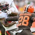 Ke'Shawn Vaughn #21 of the Tampa Bay Buccaneers runs with the ball as Jeremiah Owusu-Koramoah #28 of the Cleveland Browns defends during the first half at FirstEnergy Stadium on November 27, 2022 in Cleveland, Ohio.