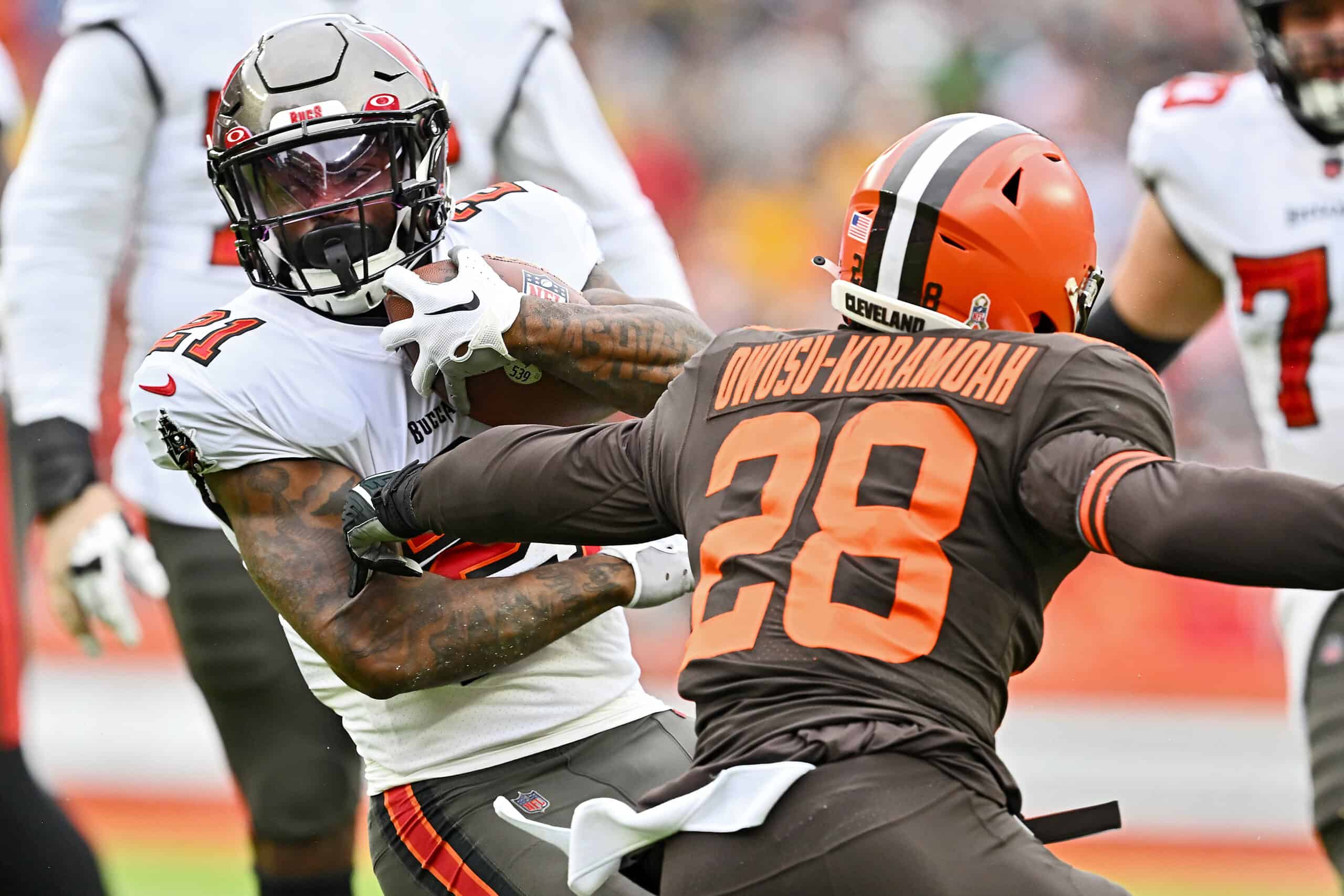 Ke'Shawn Vaughn #21 of the Tampa Bay Buccaneers runs with the ball as Jeremiah Owusu-Koramoah #28 of the Cleveland Browns defends during the first half at FirstEnergy Stadium on November 27, 2022 in Cleveland, Ohio.