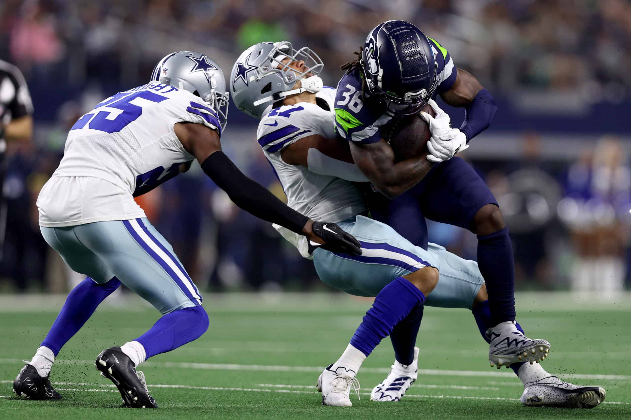 Running back Darwin Thompson #36 of the Seattle Seahawks carries the ball against linebacker Storey Jackson #47 and cornerback Nahshon Wright #25 of the Dallas Cowboys in the second half of a NFL preseason football game at AT&T Stadium on August 26, 2022 in Arlington, Texas.