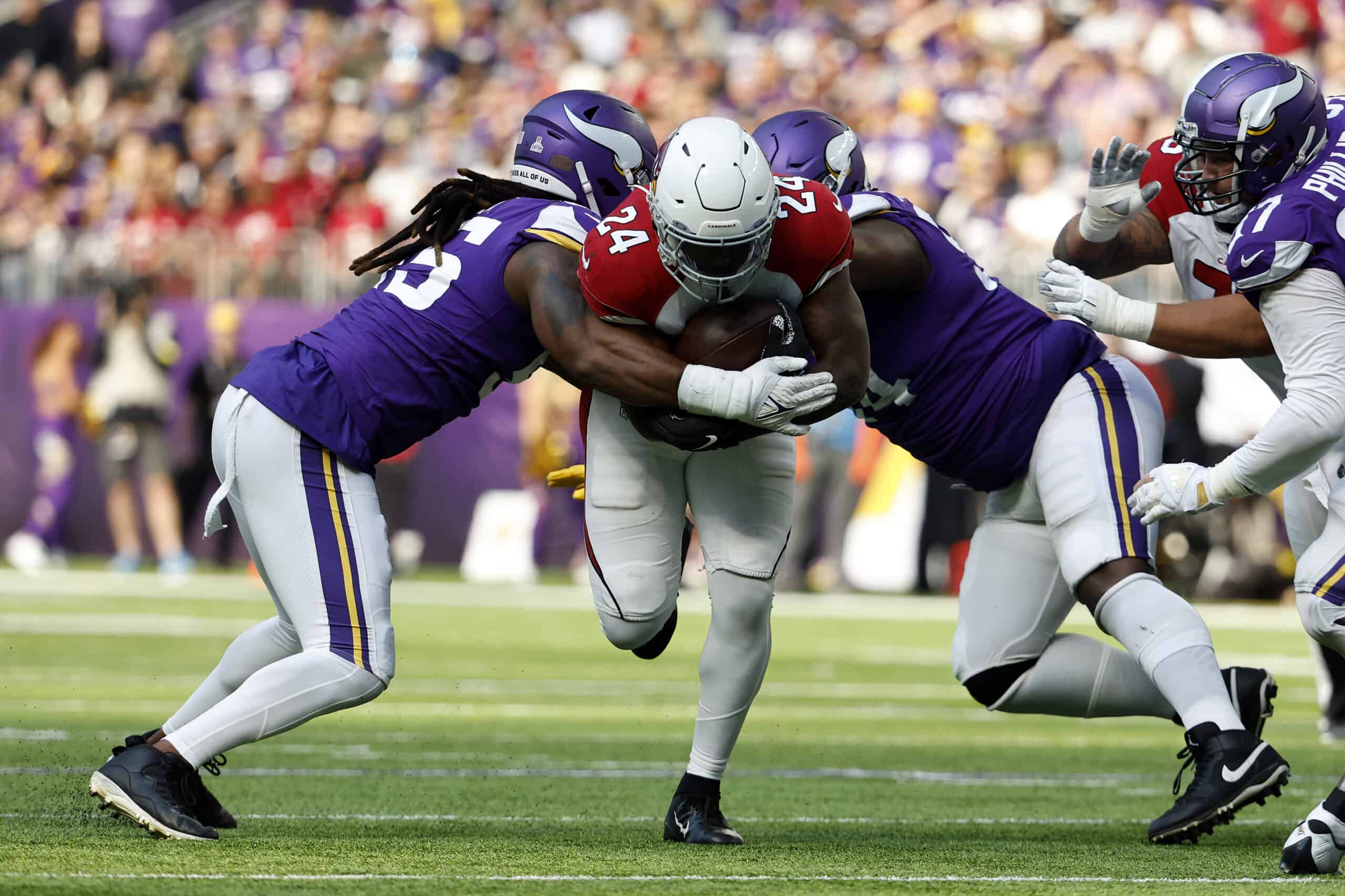 Darrel Williams #24 of the Arizona Cardinals is tackled by Za'Darius Smith #55 of the Minnesota Vikings and Dalvin Tomlinson #94 during the second quarter at U.S. Bank Stadium on October 30, 2022 in Minneapolis, Minnesota.