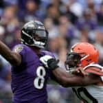 Quarterback Lamar Jackson #8 of the Baltimore Ravens gets off a pass while being pressured by defensive end Jadeveon Clowney #90 of the Cleveland Browns in the first half at M&T Bank Stadium on October 23, 2022 in Baltimore, Maryland.