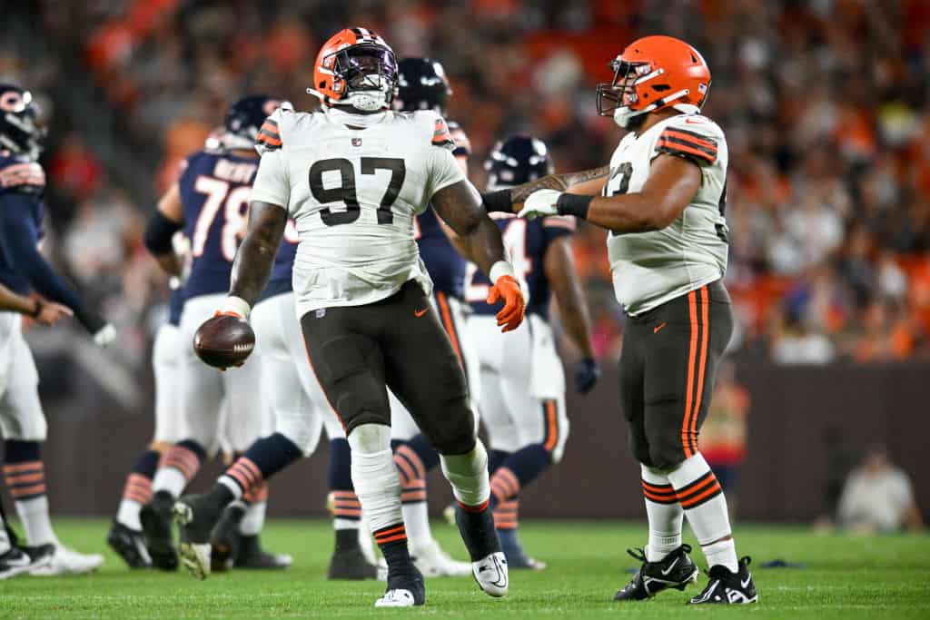 Perrion Winfrey #97 and Tommy Togiai #93 of the Cleveland Browns celebrate a fumble recover by Winfrey during the first half of a preseason game against the Chicago Bears at FirstEnergy Stadium on August 27, 2022 in Cleveland, Ohio.