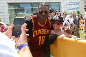 Former member of the Cleveland Browns Josh Cribbs poses with a fan during the Cleveland Cavaliers 2016 NBA Championship victory parade and rally on June 22, 2016 in Cleveland, Ohio.